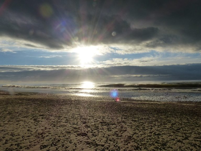 Sonnenaufgang am Meer nach Regen