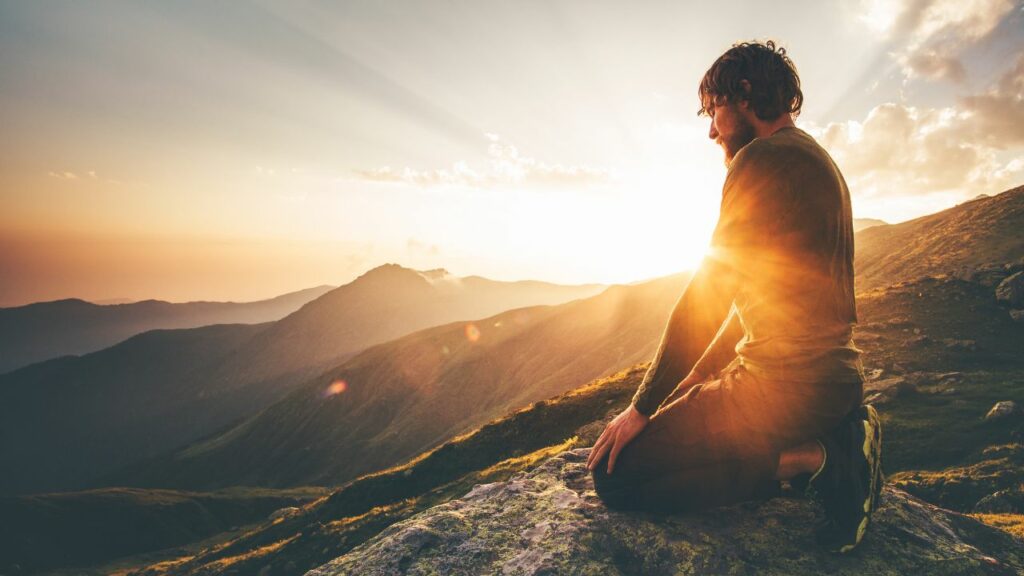 Mann sitzt bei Sonnenuntergang nachdenklich auf dem Berg, der Ärger ist vorbei