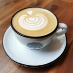 Eine Tasse Kaffe mit einem Herz aus Milchschaum als Symbol für Achtsamkeit und Kraft tanken im Hier & Jetzt